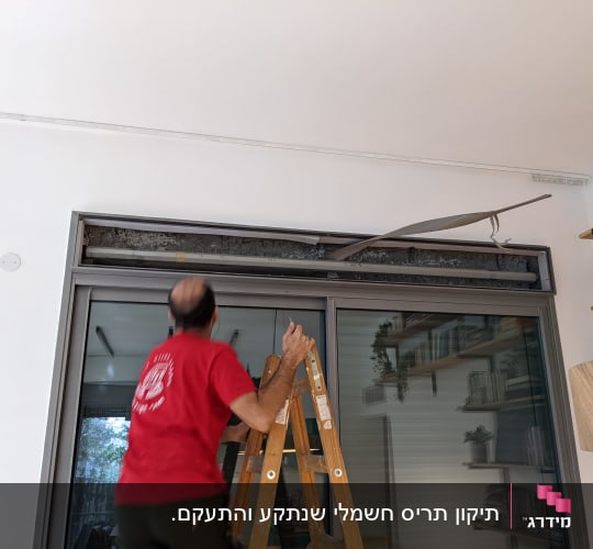 אדם על סולם מתקן תריסים שבורים